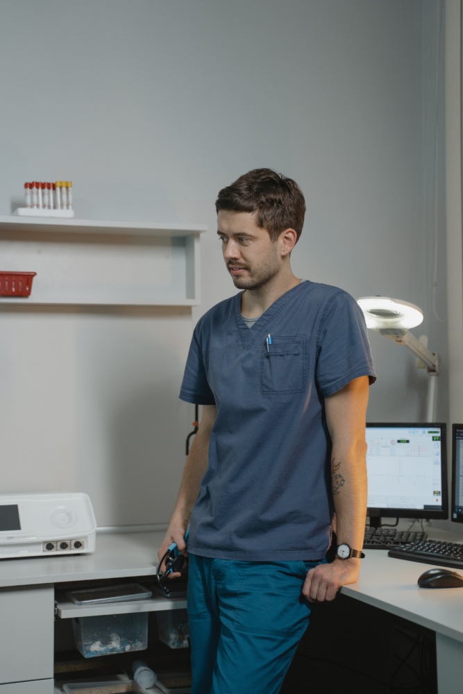 Male nurse standing at a desk.